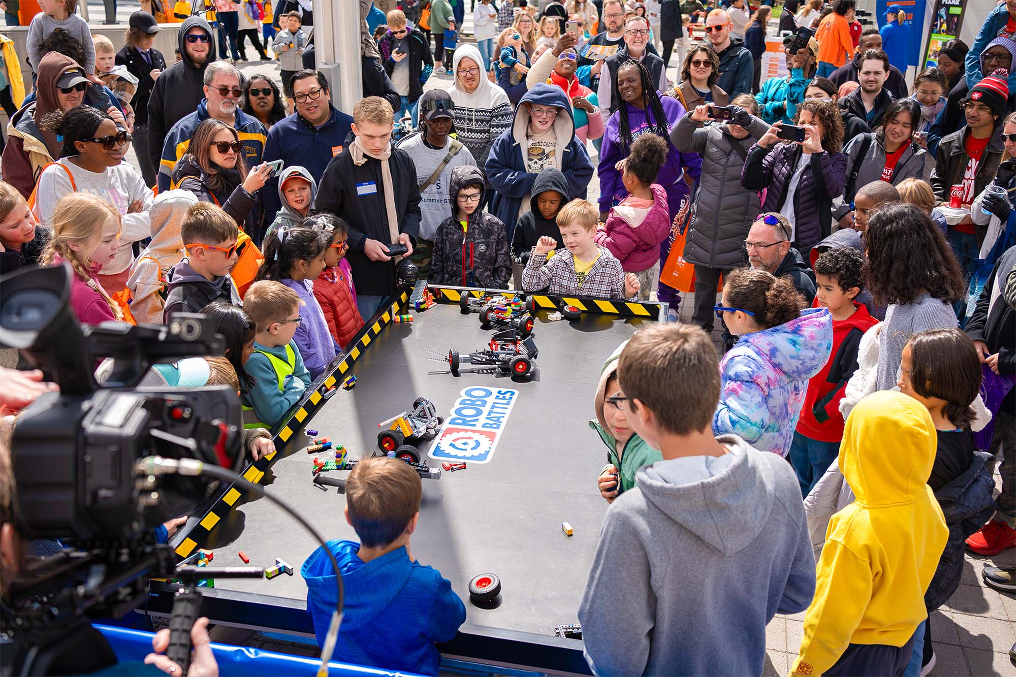 Players gathered around a RoboBattles competition arena