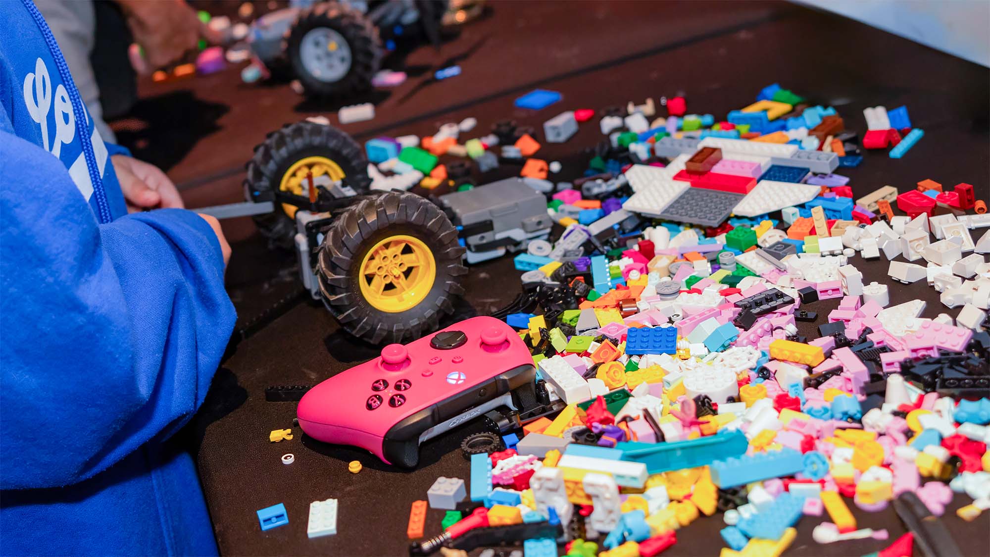 LEGO robot, loose bricks, and a pink game controller